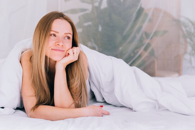 Blond meisje die zich voordeed op het bed