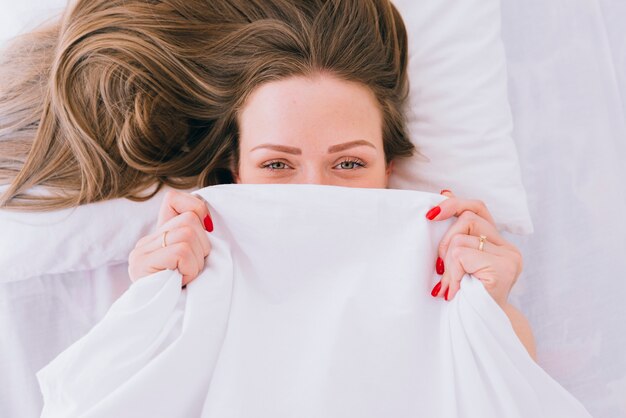 Blond meisje die zich voordeed op het bed