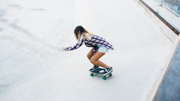 Blond meisje schaatsen met koele stijl