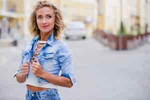 Gratis foto blond meisje staat op straat poseren