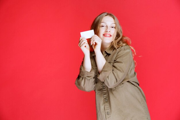 Blond meisje toont haar visitekaartje en voorzien van een netwerk.