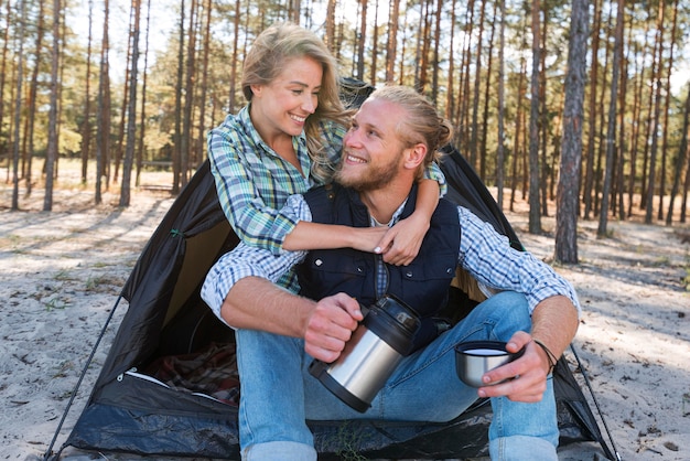 Gratis foto blond paar zit tent en knuffelen elkaar