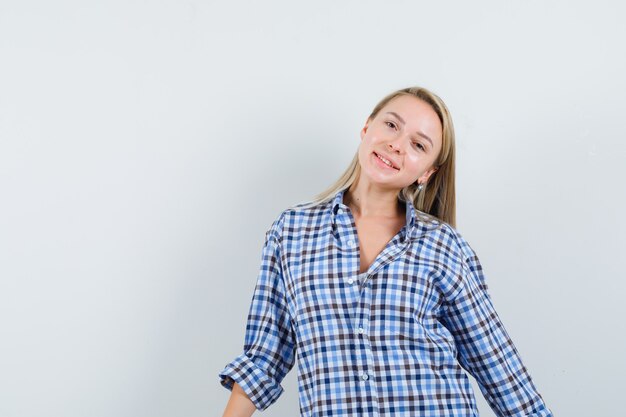Blonde dame die zich voordeed terwijl je in een casual shirt staat en er mooi uitziet