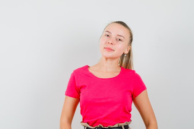 Blonde dame in roze t-shirt en ziet er schattig uit, vooraanzicht.