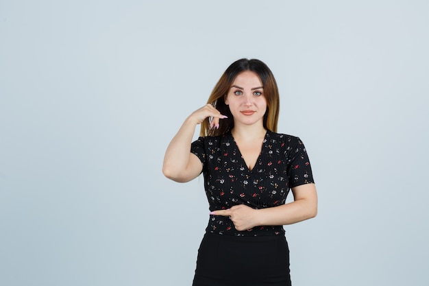 Blonde jonge dame in geïsoleerde kleding gebaren