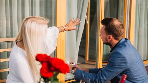 Blonde jonge vrouw diamantring tonen aan zijn vriendje