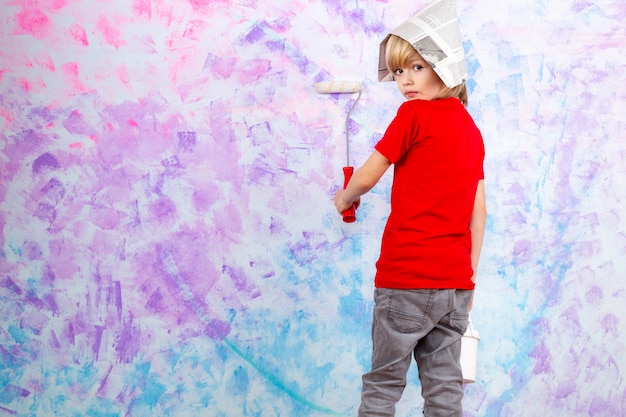 blonde jongen in rood t-shirt met kwast schilderij muren