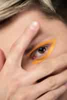 Gratis foto blonde man met oranje eyeliner