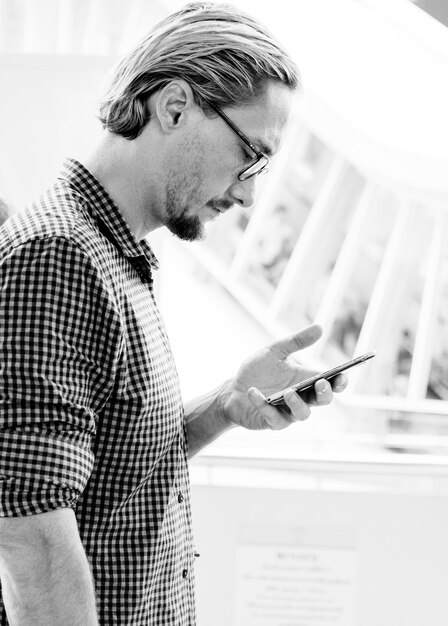 Blonde man texting op zijn telefoon