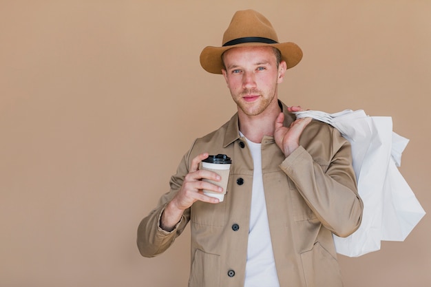 Blonde mens die met koffie aan de camera kijkt