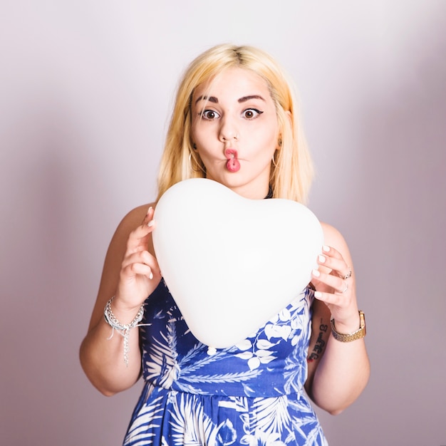 Blonde poseren met ballon en grappig gezicht