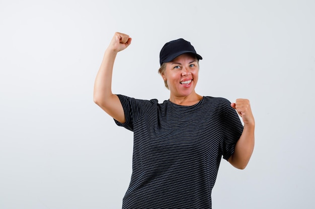 Blonde rijpe vrouw in een zwart t-shirt en een zwarte pet