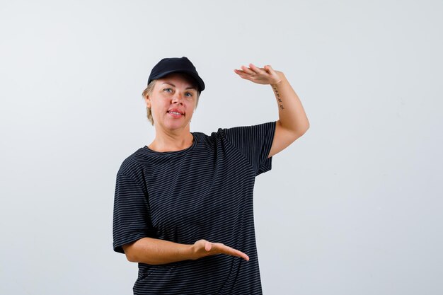 Blonde rijpe vrouw in een zwart t-shirt en een zwarte pet