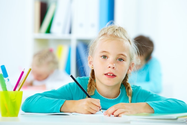 Blonde schoolmeisje met een zwart potlood