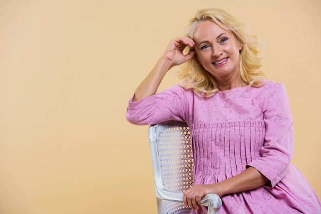 Blonde senior vrouw draagt een roze jurk