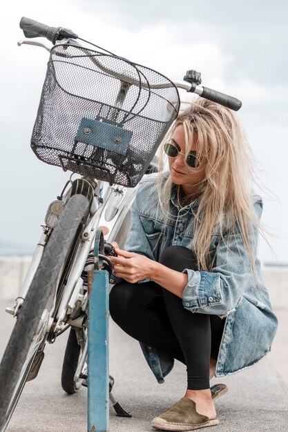 Blonde vrouw die een fietsslot zet