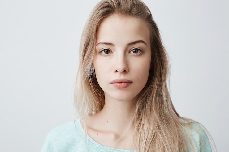 Gratis Foto blonde vrouw die met tevreden en kalme uitdrukking kijkt.