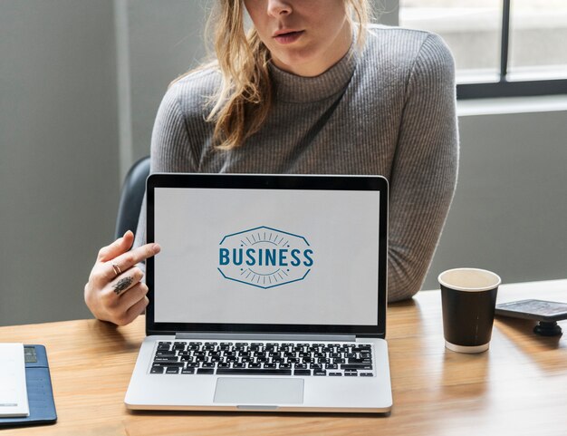 Blonde vrouw die op het laptop scherm richt