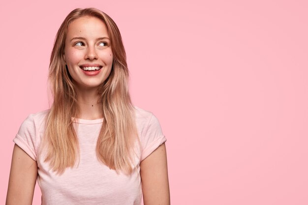 Blonde vrouw die roze T-shirt draagt