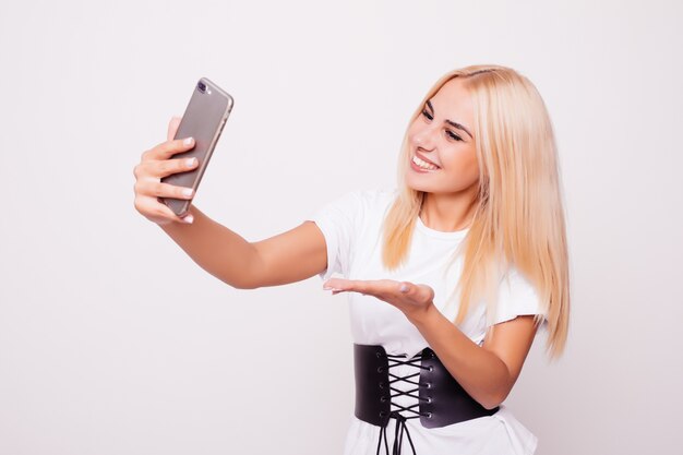 Blonde vrouw doet selfie op geïsoleerd