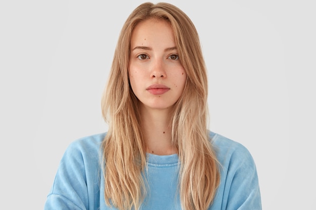 Blonde vrouw in blauw shirt poseren