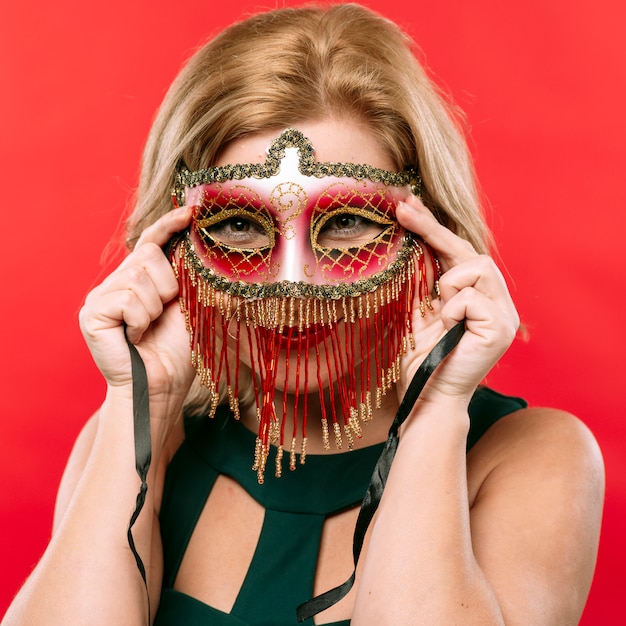 Gratis foto blonde vrouw in helder carnaval-masker