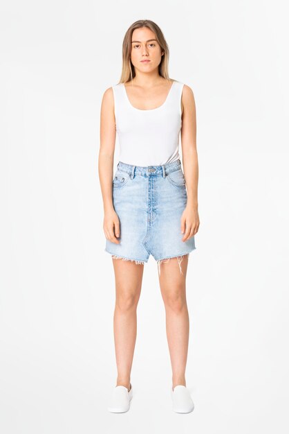 Blonde vrouw in witte tanktop en denim minirok vrijetijdskleding mode full body