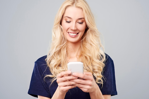 Blonde vrouw met witte smartphone