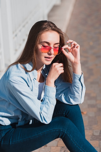 Gratis foto blonde vrouw poseren mode met zonnebril