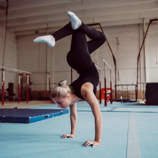 Blonde vrouw training voor Olympische gymnastiek