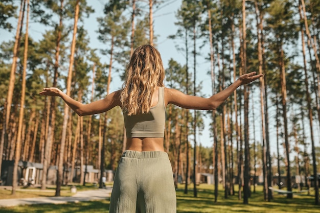 Blonde vrouw voelt zich ontspannen en vredig terwijl ze tijd doorbrengt in het park