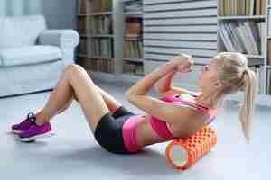 Gratis foto blonde vrouw workout oefeningen met schuimroller