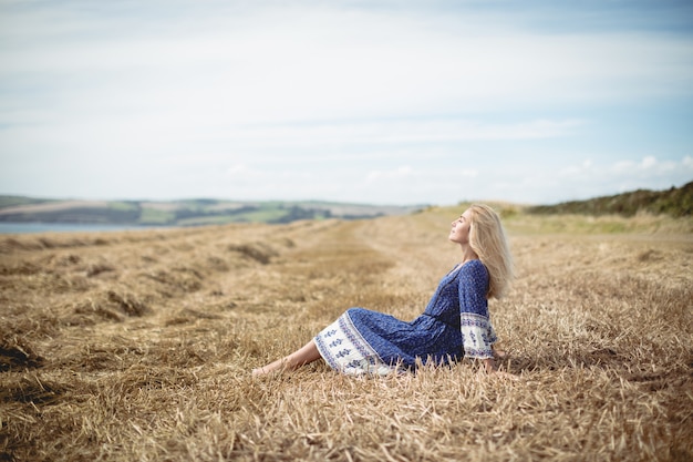 Blonde vrouw zitten in veld