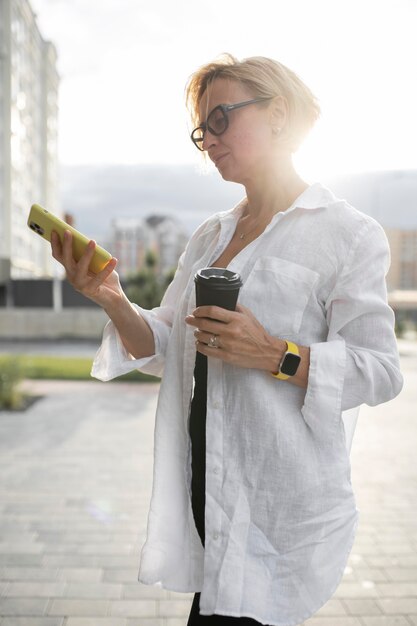 Blonde zakenvrouw die haar telefoon controleert