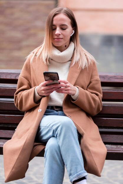 Blondemeisje die aan muziek op oortelefoons luisteren