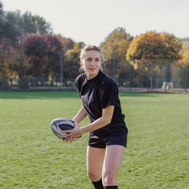 Blondevrouw die een rugbybal voorbereidingen treffen te werpen