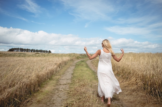 Blondevrouw die op de weg op gebied lopen