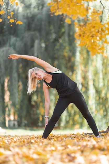 Gratis foto blondevrouw het uitrekken zich in aard