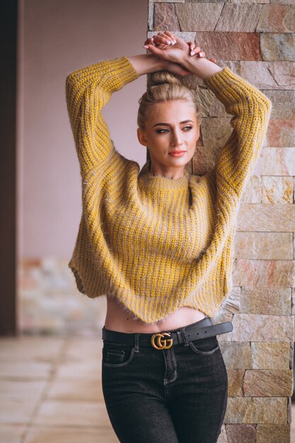 Blondevrouw in koele gele sweater