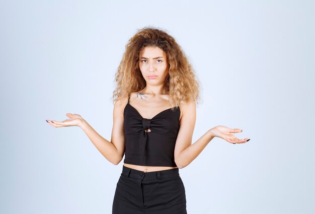 Blondie vrouw die iets in haar hand laat zien, ergens naar wijst of uitleg geeft.