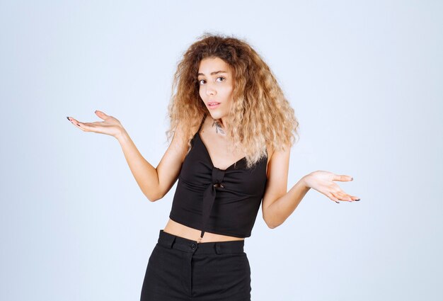 Blondie vrouw die iets in haar hand laat zien, ergens naar wijst of uitleg geeft.