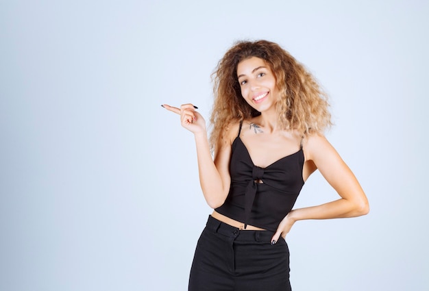 Blondiemeisje met krullende haren die naar links wijzen.