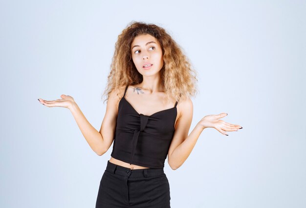 Blondiemeisje met krullende haren ziet er verward en verloren uit.