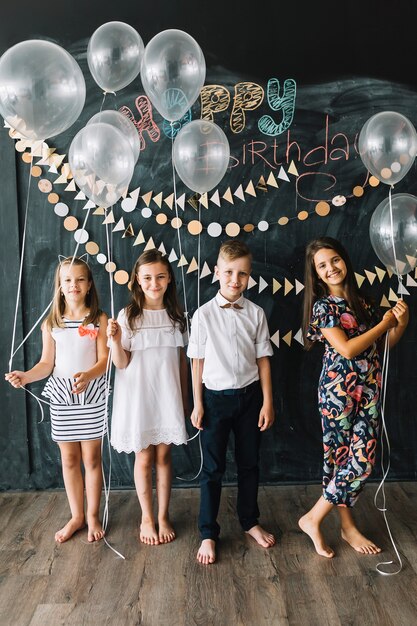 Blootsvoets kinderen met ballonnen op verjaardagsfeestje