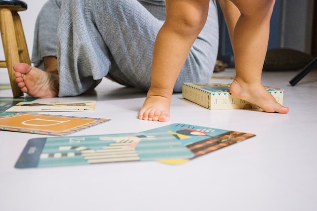 Blootvoetse baby die op kinderdagverblijfvloer loopt