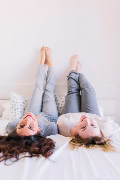 Blootvoetse vrouwen die op bed liggen