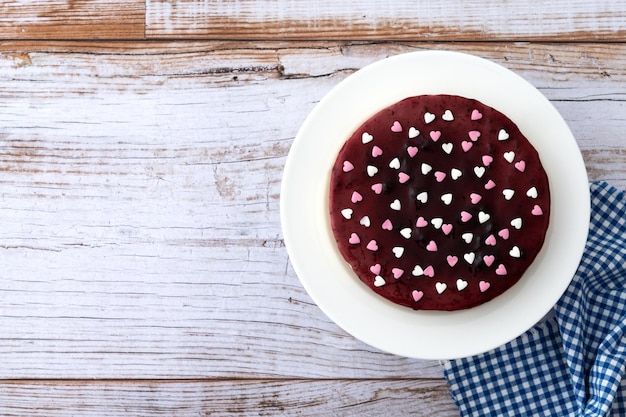 Blueberry cheesecake versierd met zoete hartjes op houten tafel