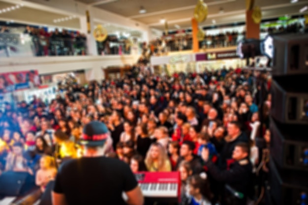 Blured foto overvolle concertzaal met scène podiumverlichting met mensen bij rock optreden