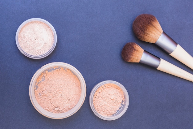 Blusher poeder en twee make-upborstel op blauwe achtergrond