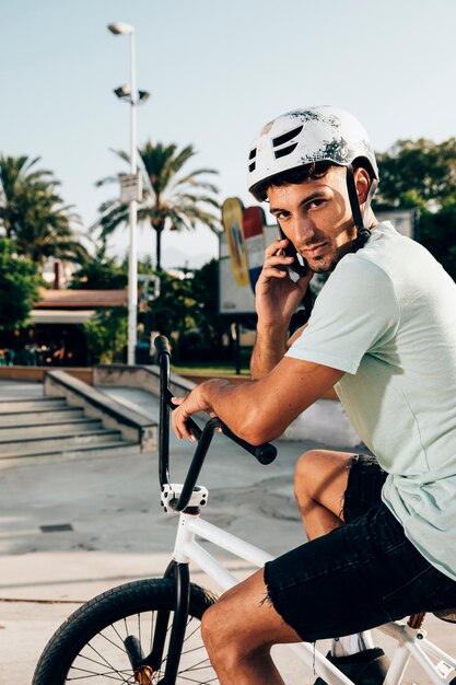 Bmx-rijder die bij het middelgrote schot van de telefoon spreekt